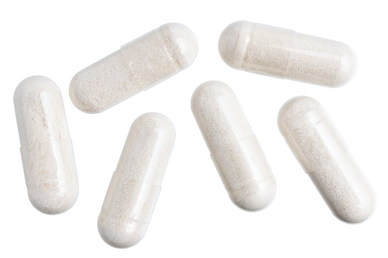 white gel medical capsules, group of vitamin supplement pills or